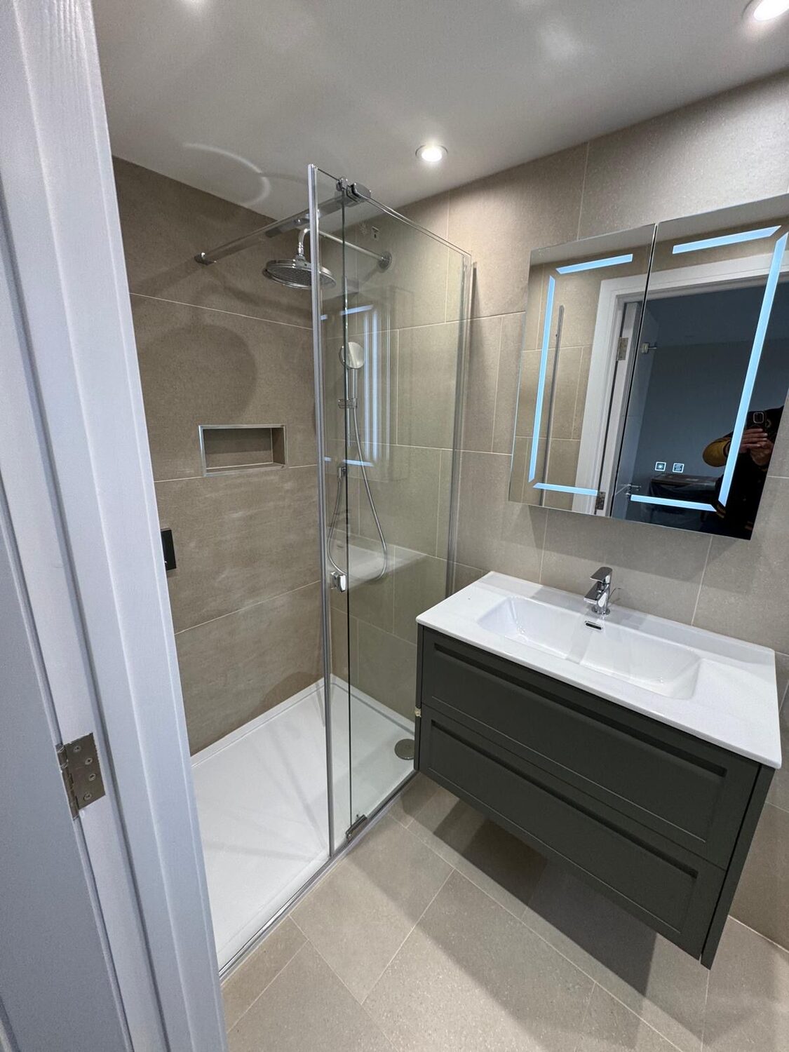 Grey wall-hung vanity, LED mirror and walk-in shower