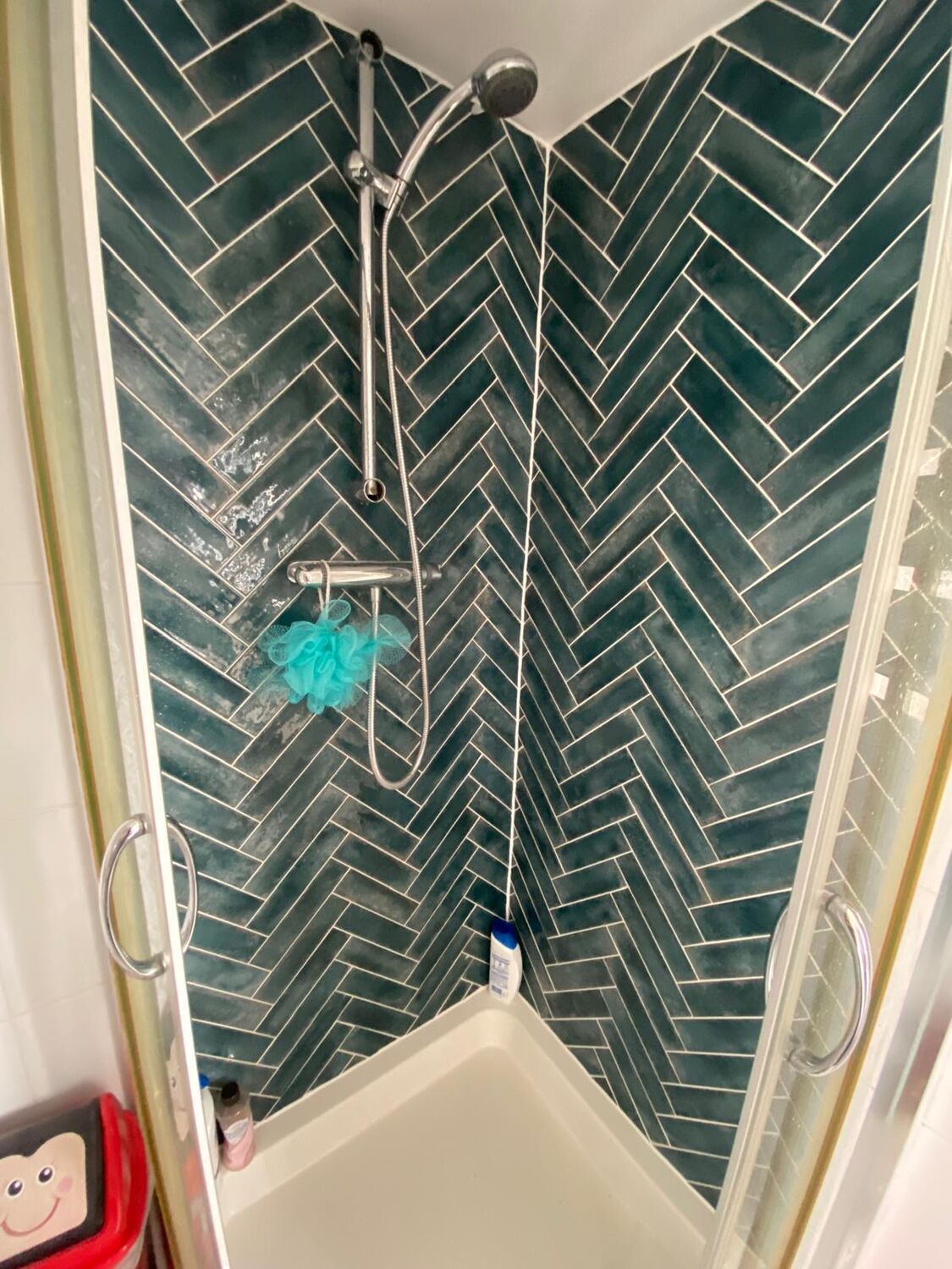 Shower with green herringbone tiles