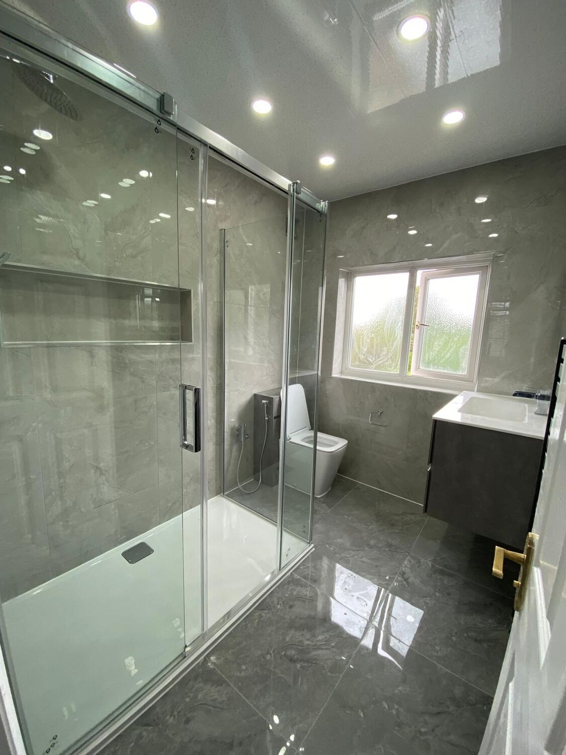 Large walk-in shower with marble-effect porcelain and black frame