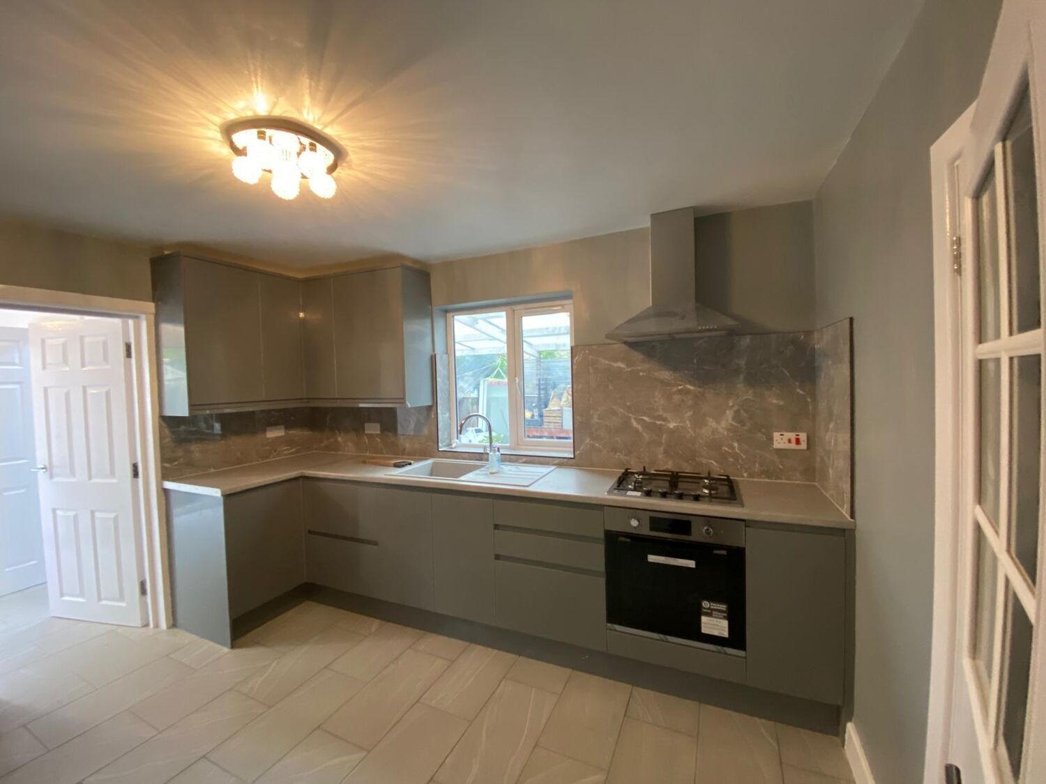 Grey handleless kitchen with marble-effect splashback