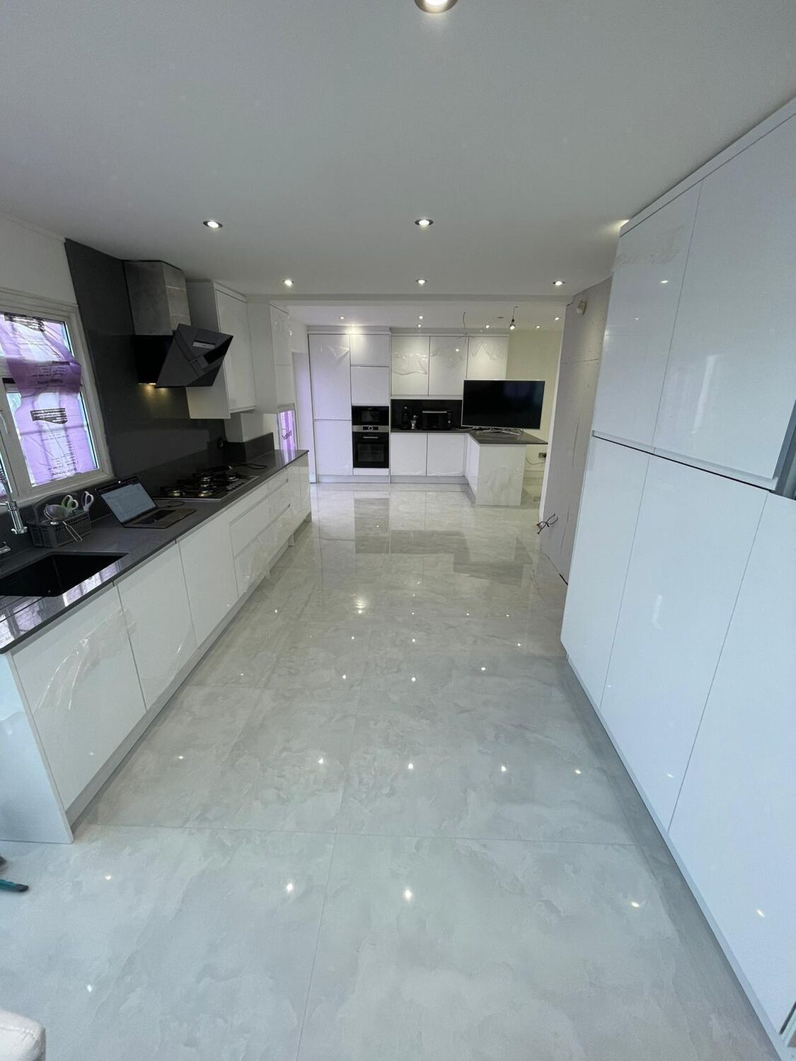 White gloss galley kitchen with polished porcelain floor