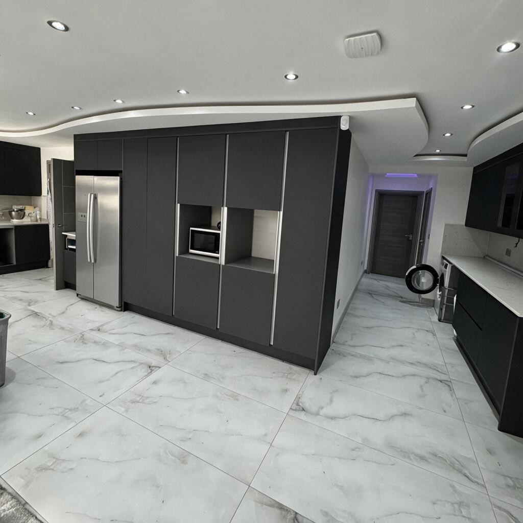 Dark handleless kitchen with tall units and marble-effect porcelain floor